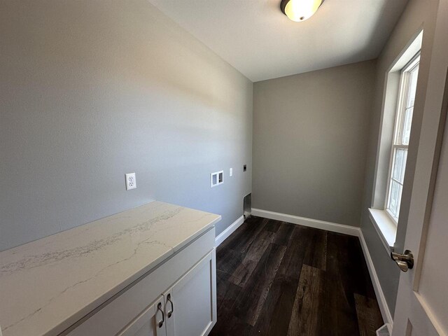 laundry area with cabinets, a healthy amount of sunlight, dark hardwood / wood-style floors, and electric dryer hookup