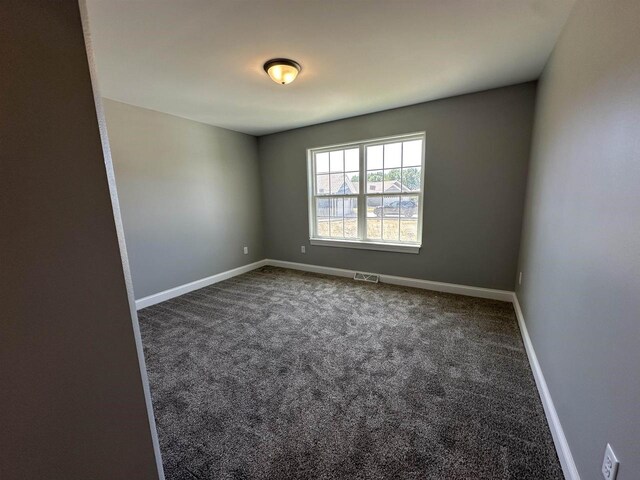 empty room with dark colored carpet