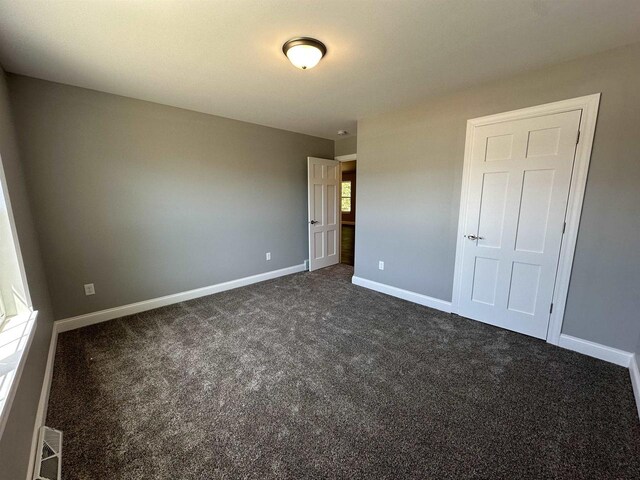 unfurnished bedroom featuring dark colored carpet