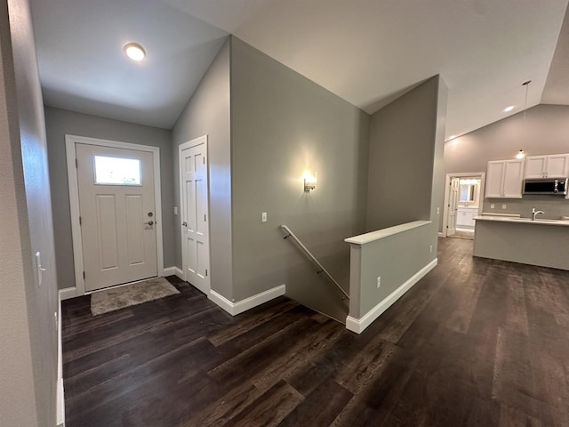 entrance foyer featuring vaulted ceiling and dark hardwood / wood-style floors