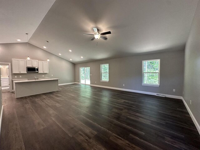 unfurnished living room featuring ceiling fan, sink, dark wood-type flooring, and lofted ceiling