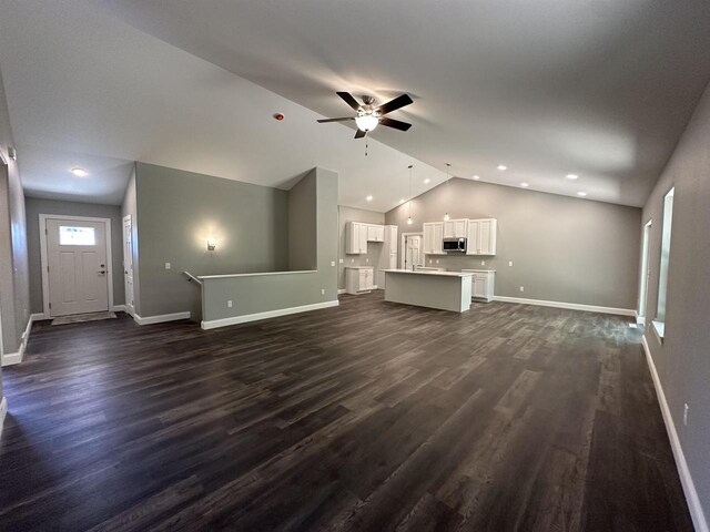 unfurnished living room featuring dark hardwood / wood-style flooring, ceiling fan, and lofted ceiling