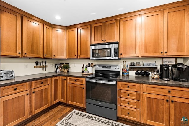 kitchen with dark wood-type flooring and stainless steel appliances