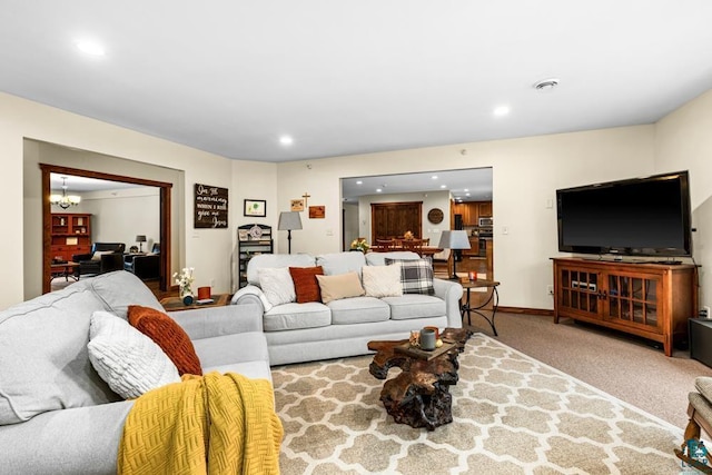 carpeted living room with a notable chandelier