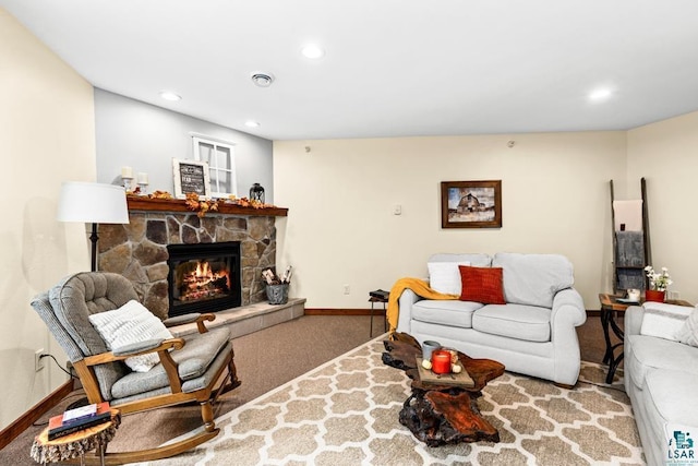 carpeted living room with a stone fireplace