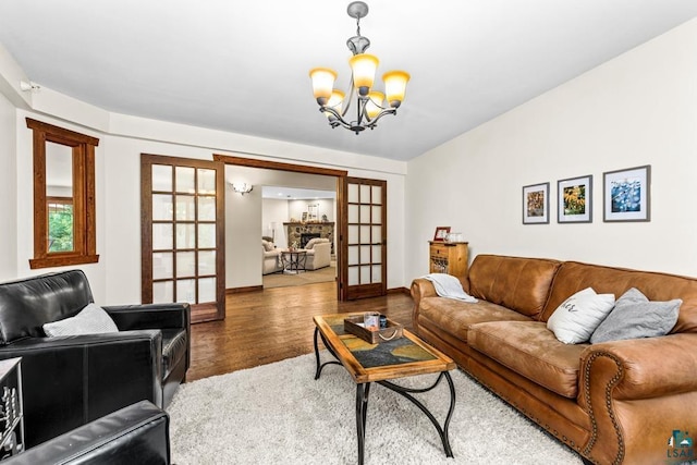 living room with french doors, a chandelier, and hardwood / wood-style floors