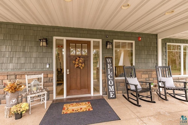 view of exterior entry featuring covered porch