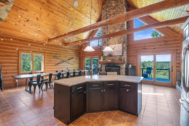 kitchen featuring decorative light fixtures, a fireplace, high vaulted ceiling, and a kitchen island