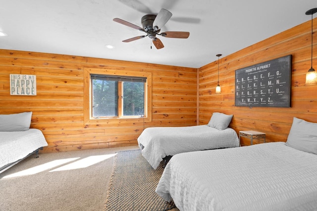 carpeted bedroom with wooden walls and ceiling fan