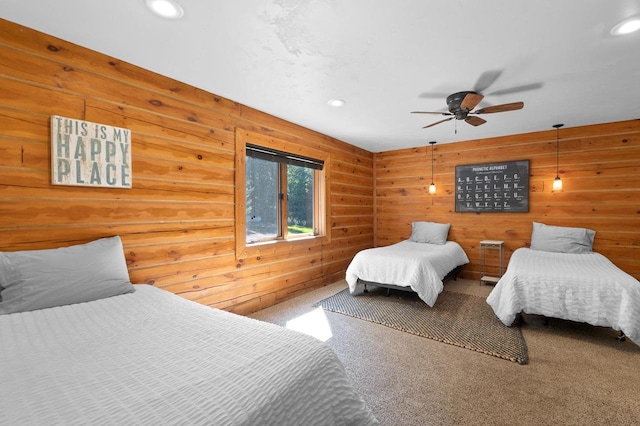 bedroom featuring carpet, ceiling fan, and wood walls