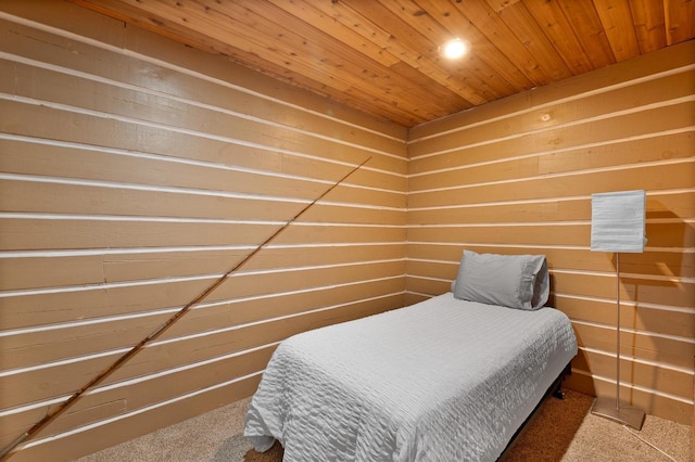 bedroom with carpet, wood ceiling, and wooden walls