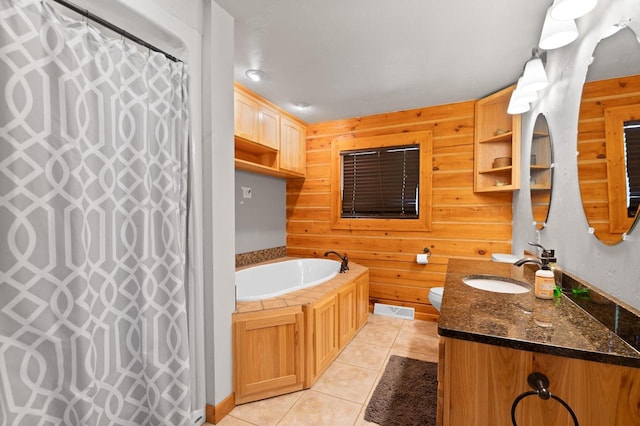 bathroom with wooden walls, vanity, a washtub, and tile patterned floors