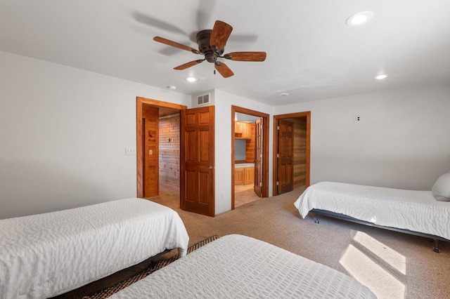 carpeted bedroom with ceiling fan and ensuite bathroom