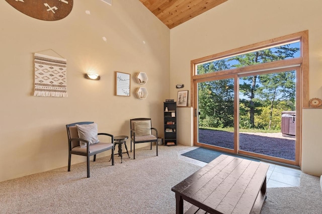 living area with light colored carpet, wood ceiling, and high vaulted ceiling