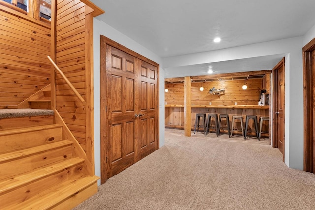 interior space with wood walls and carpet flooring