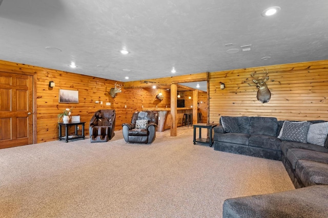 carpeted living room featuring wooden walls