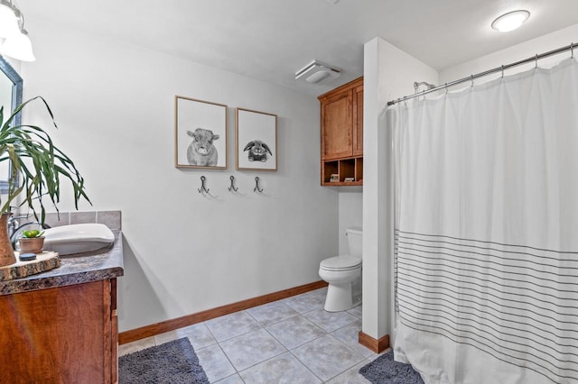 bathroom with tile patterned flooring, vanity, and toilet