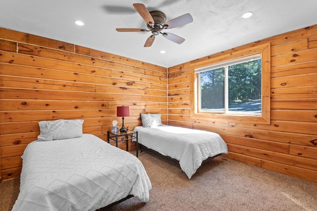 bedroom featuring wooden walls, carpet, and ceiling fan