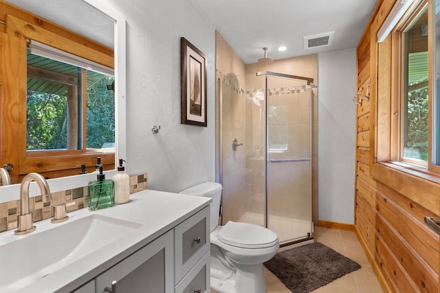 bathroom with tile patterned flooring, an enclosed shower, vanity, and toilet