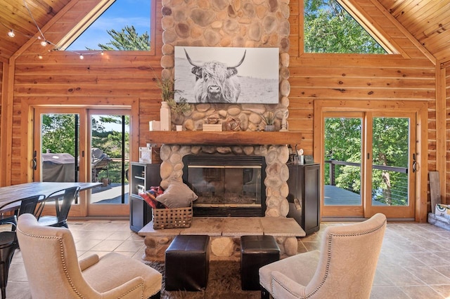 tiled living room with wooden ceiling, a stone fireplace, and high vaulted ceiling