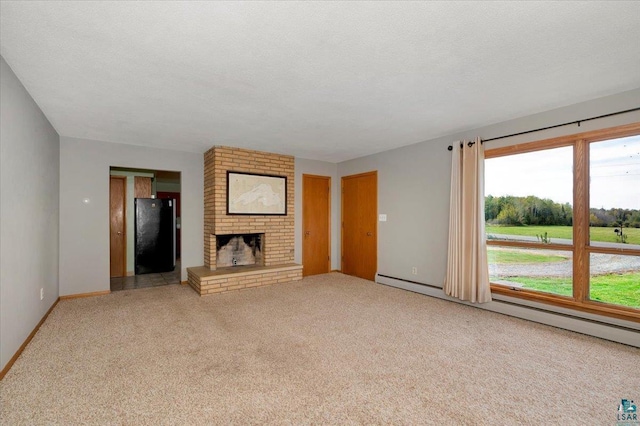 unfurnished living room with baseboard heating, light colored carpet, a brick fireplace, and a textured ceiling