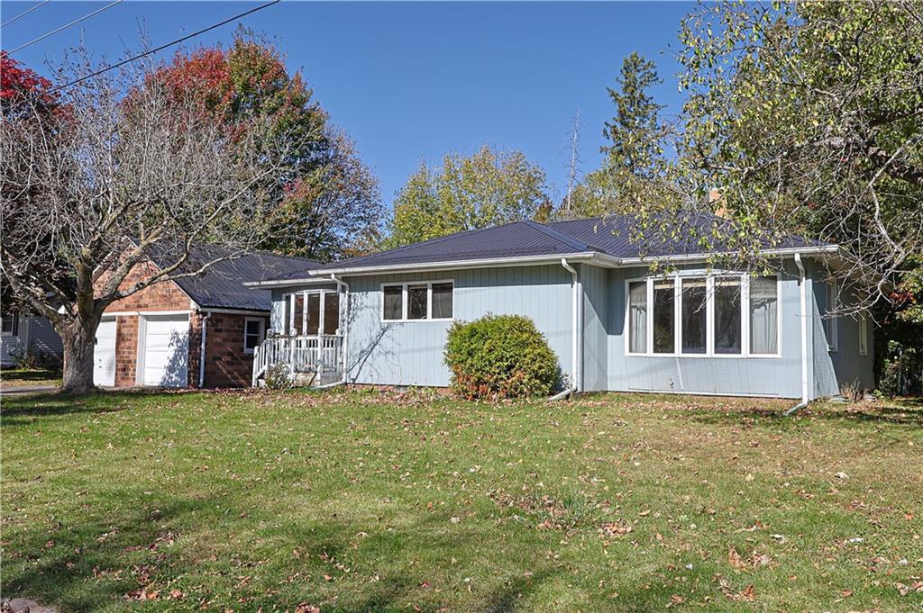 back of property featuring a lawn and a garage