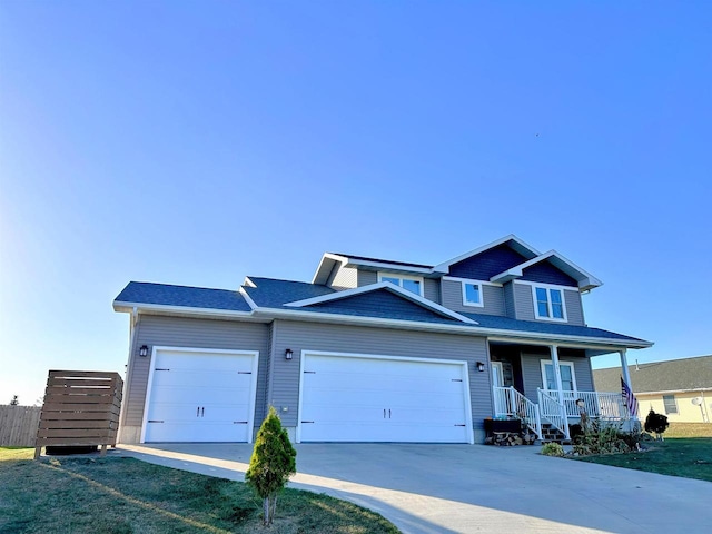 view of front of house with a front yard, a garage, and covered porch