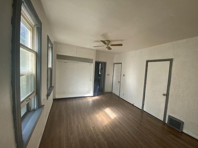 unfurnished room featuring ceiling fan and dark wood-type flooring