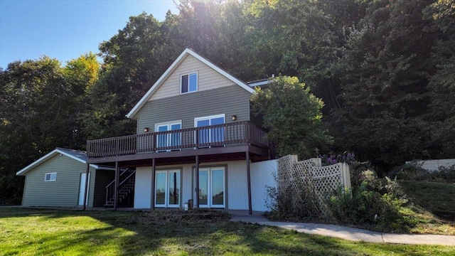 back of property with a yard, a deck, and french doors