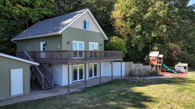 back of house with a playground, a deck, a lawn, and a patio