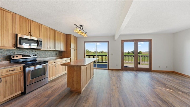 kitchen featuring appliances with stainless steel finishes, dark wood-type flooring, pendant lighting, a textured ceiling, and a center island