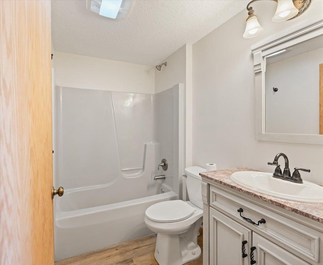 full bathroom with vanity, a textured ceiling, shower / bathtub combination, hardwood / wood-style floors, and toilet