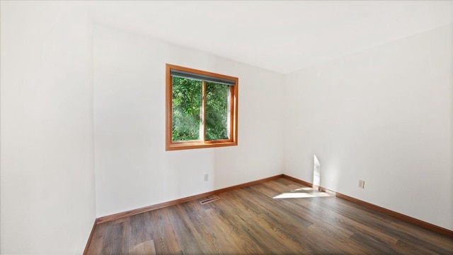 unfurnished room with dark wood-type flooring