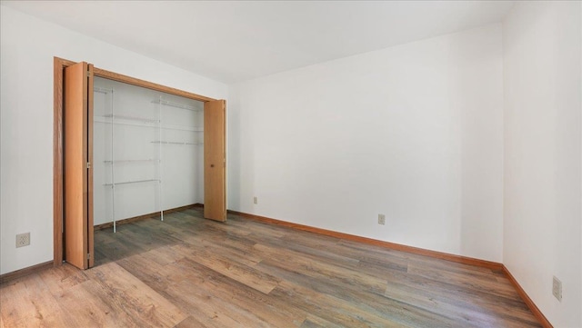 unfurnished bedroom featuring a closet and hardwood / wood-style flooring