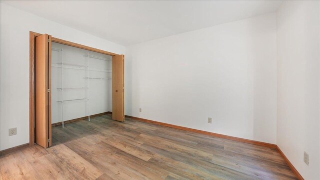 W9037 Ridgeview Trl, New Lisbon, WI 53950 - unfurnished bedroom with light wood-type flooring, baseboards, and a closet