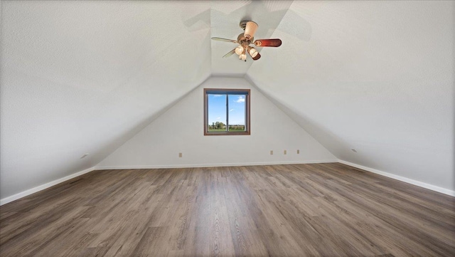 additional living space featuring a textured ceiling, vaulted ceiling, hardwood / wood-style floors, and ceiling fan