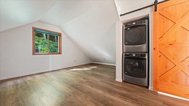 W9037 Ridgeview Trl, New Lisbon, WI 53950 - washroom featuring stacked washer / dryer, wood finished floors, a barn door, and baseboards