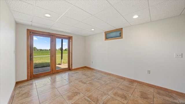 unfurnished room featuring a paneled ceiling and light tile patterned floors