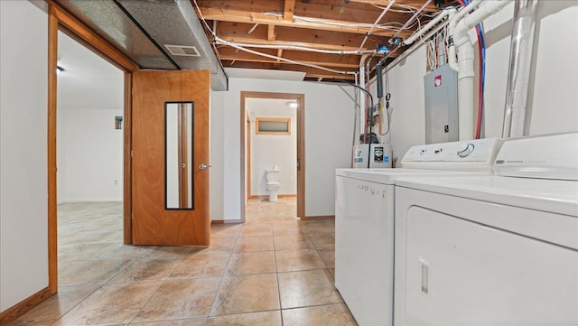 laundry room with washer and clothes dryer, light tile patterned flooring, electric panel, and water heater