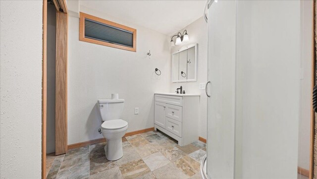 W9037 Ridgeview Trl, New Lisbon, WI 53950 - bathroom featuring stone finish flooring, vanity, baseboards, toilet, and a stall shower
