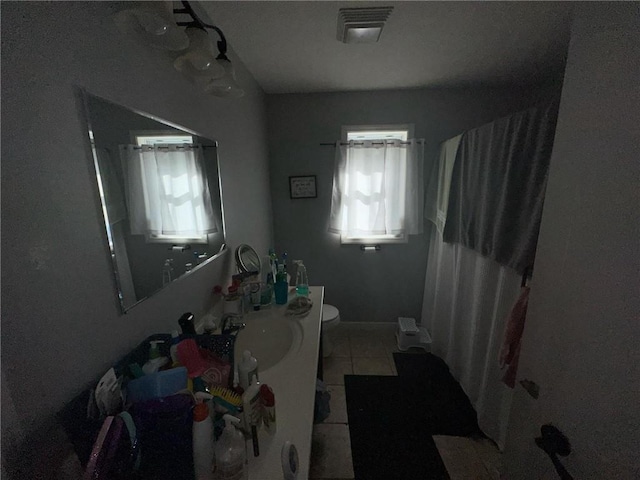 bathroom with a shower with shower curtain, tile patterned floors, vanity, and toilet