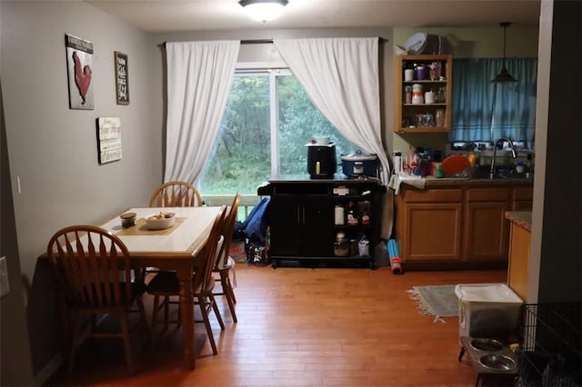 dining area with light hardwood / wood-style floors and sink