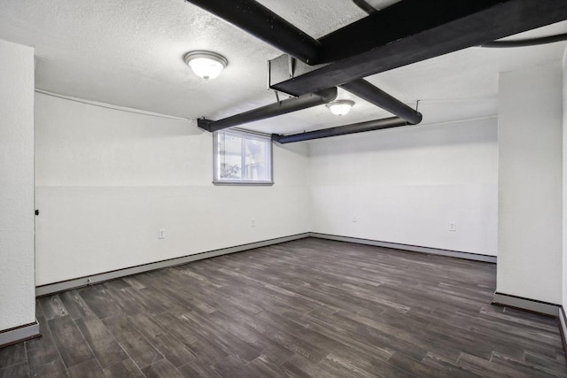 basement featuring a textured ceiling and dark hardwood / wood-style flooring