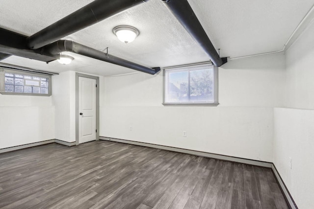 basement with a textured ceiling, hardwood / wood-style floors, and a healthy amount of sunlight