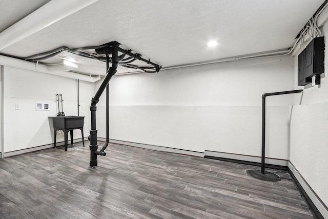 basement featuring a baseboard radiator and dark hardwood / wood-style floors