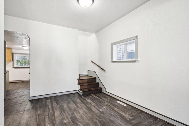 spare room with dark wood-type flooring and a textured ceiling