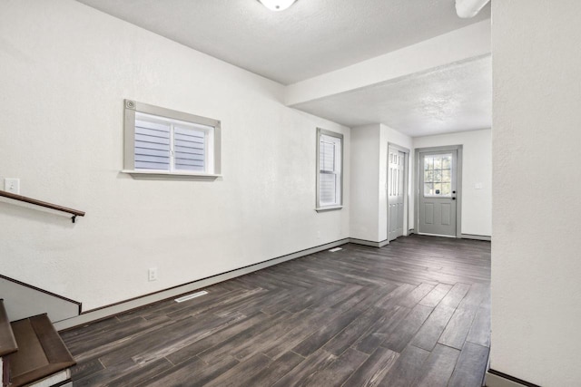 foyer entrance with a textured ceiling and dark hardwood / wood-style flooring