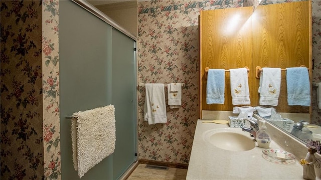 bathroom with walk in shower and vanity