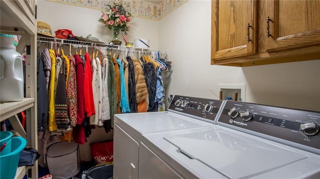 laundry room with washing machine and dryer and cabinets