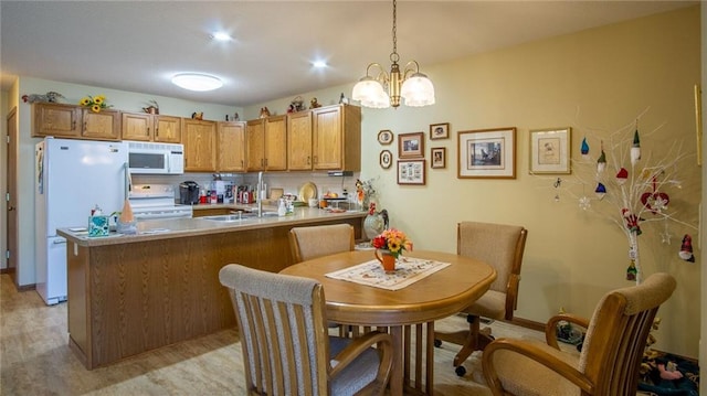 kitchen with decorative backsplash, white appliances, pendant lighting, an inviting chandelier, and light hardwood / wood-style flooring